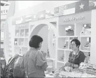  ?? WANG ZHUANGFEI / CHINA DAILY ?? A visitor to the ASEAN Pavilion of the ASEAN Expo selects food products.