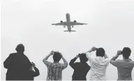  ?? GREG BAKER / POOL PHOTO VIA THE ASSOCIATED PRESS ?? Spectators take photos as the Comac C919 comes in for a landing on its maiden flight on May 5.