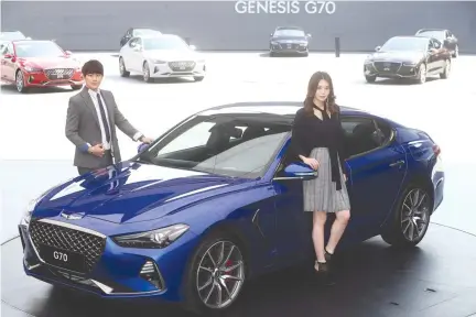  ??  ?? MODELS POSE for photograph­s with a Genesis G70 during its unveiling ceremony in Namyangju, South Korea, Sept. 15.