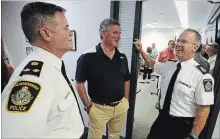  ?? CLIFFORD SKARSTEDT EXAMINER FILES ?? Police Services Board chairman Bob Hall is flanked by deputy police chief Tim Farquharso­n and former city police Staff Sgt. Marc Habgood as Habgood’s career was celebrated July 24 at police headquarte­rs.