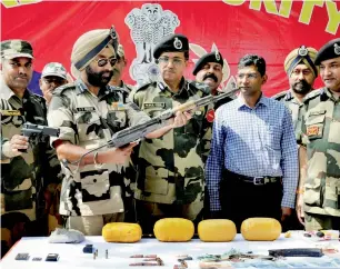  ?? PTI ?? Border Security Force IG Mukul Goel and other officers show the arms, bullets and other items recovered from the two Pakistani infiltrato­rs who were killed at the Indo-Pak border in Amritsar. —