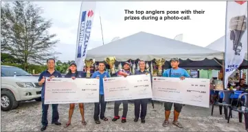  ??  ?? The top anglers pose with their prizes during a photo-call.