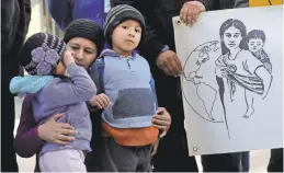  ?? JEFF CHIU/AP ?? Angela Henriquez hugs her children at a rally supporting Temporary Protected Status outside a federal courthouse in San Francisco in March.