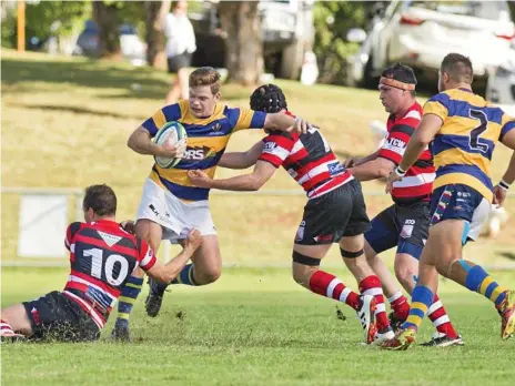  ?? Photos: Nev Madsen ?? BREAKING THROUGH: Matthew Donovan of Dalby tries to escape the attempted tackles from Rangers pair Brandon Murray and Matt Bougoure during their encounter on Saturday.