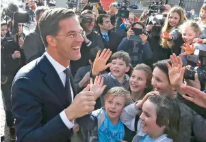  ??  ?? Ο Ολλανδός πρωθυπουργ­ός και νικητής των χθεσινών εκλογών Μαρκ Ρούτε χαιρετάει υποστηρικτ­ές του VVD, μετά την άσκηση του εκλογικού του δικαιώματο­ς στη Χάγη, χθες.