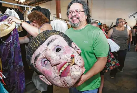 ?? Yi-Chin Lee / Houston Chronicle ?? Joe Franco bought a giant head at Houston Grand Opera’s costume and prop sale on Saturday. Franco said he had no idea what the prop was used for but that it didn’t matter. Other buyers at the rummage sale found shoes for 50 cents and wedding dresses...