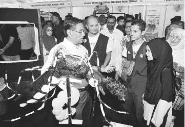  ??  ?? Visitors being briefed by Dr Subramania­m on the new method to fight dengue after he launched the national-level Asean Dengue Day 2017. — Bernama photo