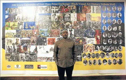  ?? Picture: SINO MAJANGAZA ?? RECOGNITIO­N: Artist and project convenor Thando Mama stands against the wall of tribute to black artists who have played a significan­t role in the field of arts and culture in South Africa over the years, at the University of Fort Hare Print Exchange...