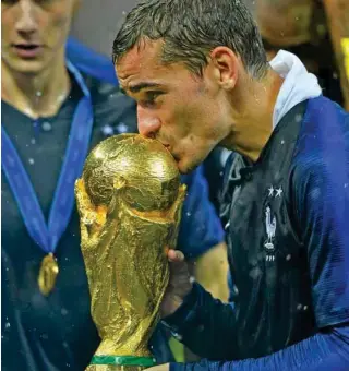  ?? – Reuters ?? PRECIOUS: France’s Antoine Griezmann kisses the trophy as he celebrates winning the World Cup at the Luzhniki Stadium, Moscow, Russia.
