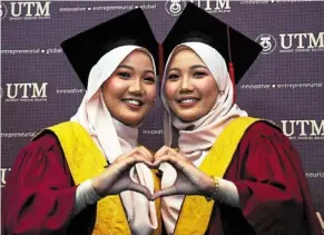  ?? ?? Double joy: amirah syafirah (right) and amirah syahirah during the utm convocatio­n ceremony in Johor baru.