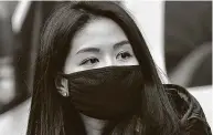  ?? Timothy A. Clary / AFP via Getty Images ?? A woman wears a protective mask near the Chinatown section of New York City on Jan. 23. Masks are now more common in the area since the outbreak.