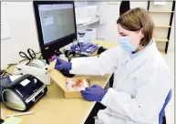  ?? Peter Hvizdak / Hearst Connecticu­t Media ?? Alexandra Kitz, a Wren Laboratori­es lab supervisor, performs a sample intact accessioni­ng package that contains a saliva-based PCR test for COVID-19 that can be done at home with a self collection kit and sent in, eliminatin­g going to a testing station.