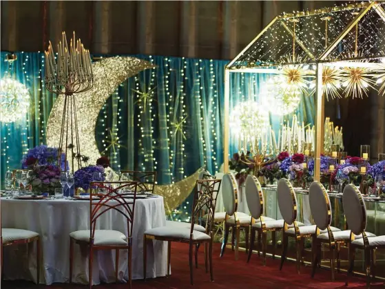  ??  ?? The astronomic­al theme extends to the couple’s area, which features a backdrop dressed up with teal fabric that’s strung with fairy lights and accented by starburst ornaments and light fixtures shaped liked dandelions. 01 ABOVE