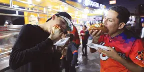  ?? ?? l Miguel Cano y Rubén Rico fueron los primeros en obtener un hotdog gratis de la promoción de Dogos Miami.