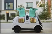  ??  ?? Self-driving vehicle “R2” carries bags of groceries. The vehicles previously were subject to federal standards for low-speed vehicles that travel under 25miles per hour.