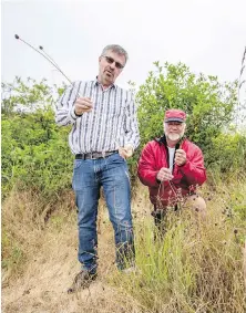  ?? DARREN STONE, TIMES COLONIST ?? Wylie Thomas, left, and Jacques Sirois, with invasive crow garlic at Cattle Point. They are spearheadi­ng a campaign to put in trails to keep people from trampling endangered plants at Cattle Point.