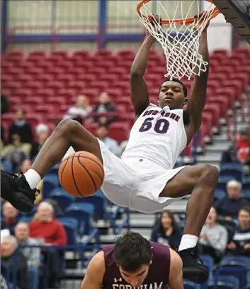 ?? Peter Diana/Post-Gazette ?? Duquesne’s Eric Williams Jr. dunks for two of his team-high 16 points against Fordham Wednesday night at Palumbo Center.