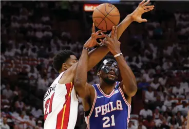  ?? Associated Press ?? ■ Philadelph­ia 76ers center Joel Embiid (21) and Miami Heat center Hassan Whiteside (21) battle for a loose ball in the first quarter in Game 4 of a first-round NBA basketball playoff series Saturday in Miami.