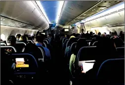  ?? TRIBUNE NEWS SERVICE ?? Main cabin passengers pass the time aboard American Airlines flight 2331, a Boeing 787-800 Dreamliner, an route from Chicago O’Hare Internatio­nal Airport to Dallas/Fort Worth Internatio­nal Airport, on Mar. 5, 2018.