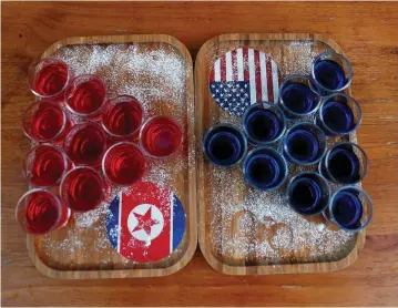  ??  ?? SPECIAL RED AND BLUE shots offered at Escobar bar to mark the summit meeting between Donald Trump and Kim Jong Un are displayed on a table in Singapore last week.