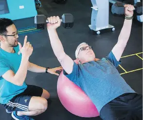  ?? BEN NELMS ?? Grant Cameron exercises with trainer Leo Iizuka at a Live Well Exercise Clinic in Vancouver. Cameron, 65, who had a heart attack two years ago, was told by doctors that exercise is the best path toward avoiding anther attack.