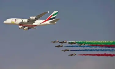  ?? THE ASSOCIATED PRESS ?? An Emirates Airline A380 leads the “Al Fursan,” or the Knights, a UAE Air Force aerobatic display team, Sunday during the opening day of the Dubai Air Show, United Arab Emirates.