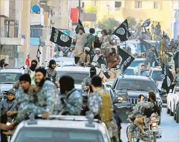  ?? Raqqah Media Center ?? MILITANTS brandishin­g the f lag of Islamic State parade in Raqqah, Syria, in an image posted by an opposition group in June 2014. The city was the de facto capital of Islamic State’s self-proclaimed caliphate.