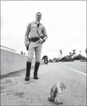  ?? California Highway Patrol Santa Barbara ?? A HIGHWAY PATROL officer guards a barn owl struck by a car in Santa Barbara last month. Rescuers say the bird, now healed, will soon be released.