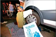  ?? AP PHOTO BY ROB SCHUMACHER ?? In this file photo, a protester locked himself to the van carrying Guadalupe Garcia de Rayos that is stopped by protesters outside the Immigratio­n and Customs Enforcemen­t facility in Phoenix.