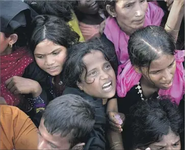  ?? Allison Joyce Getty Images ?? ROHINGYA REFUGEES wait for aid in Cox’s Bazar, Bangladesh. The country has been overwhelme­d with the massive influx of Rohingya from Myanmar. “A humanitari­an crisis is going on here,” a local official said.