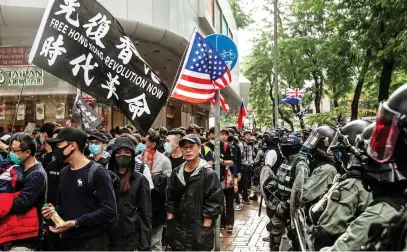  ?? Picture: AFP ?? Riot police look on as pro-democracy protesters march along a street during a demonstrat­ion against parallel trading in Sheung Shui, Hong Kong, yesterday.