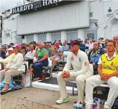  ?? AFP ?? England captain Joe Root (second right) sits in the pavilion stand before returning to the field.