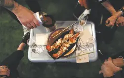  ??  ?? Anthony Strong, top, prepares an appetizer for his customers relaxing under the awning of his van and, above, serves Maine lobster with fondue. He enjoys the rustic cooking and familystyl­e vibes of SuperStell­a.