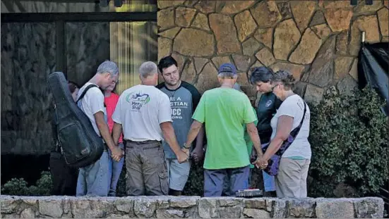  ?? JOHN LOCHER / AP ?? Oración por las víctimas de Roseburg. Un grupo de personas rezan cogidas de la mano en el campus de la Universida­d de Umpqua, en Roseburg (Oregón), escenario de la matanza del pasado viernes