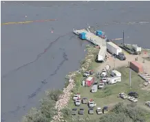  ?? JASON FRANSON/ THE CANADIAN PRESS ?? Crews work to clean up an oil spill on the North Saskatchew­an River near Maidstone on Friday. Husky Energy has said between 200,000 and 250,000 litres of crude oil and other material leaked into the river on Thursday from its pipeline.