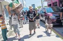  ?? JOHAN ORDONEZ / AFP ?? TOPIC OF CONTENTION: Honduran migrant, Luis Lopez, taking part in a caravan heading to the U.S., walks with his dog during a stop in their journey in Mexico.