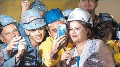  ?? AFP ?? Sonrisas. Dilma Rousseff posa, con trabajador­es de la construcci­ón, durante un acto en abril pasado.