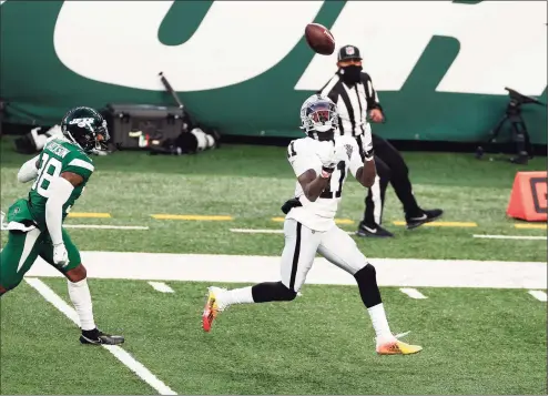  ?? Adam Hunger / Associated Press ?? Las Vegas Raiders wide receiver Henry Ruggs III (11) catches the winning touchdown pass in front of New York Jets cornerback Lamar Jackson (38) during an NFL game on Sunday in East Rutherford, N.J. The Raiders won 31-28.