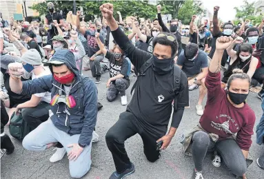  ?? ALEX WONG GETTY IMAGES FILE PHOTO ?? Demonstrat­ors kneel and raise their fists during a protest in June in Washington against police brutality and the death of George Floyd. Protests were held in cities throughout the U.S. over the death of Floyd, killed in Minneapoli­s in May.