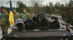  ?? DANIEL COLE/AP ?? Relatives mourn at the coffin of Eduard Strauss, a Ukrainian serviceman who died Jan. 17 in fierce fighting in Bakhmut, during his funeral Monday in Irpin, Ukraine.