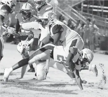  ?? ANDREW ULOZA FOR THE MIAMI HERALD ?? Piper Bengals running back Jahsharie Pinnock is taken down by Plantation Colonels defenders during Piper’s 24-21 victory to win the District 12-3M championsh­ip on Friday at PAL Stadium in Fort Lauderdale.