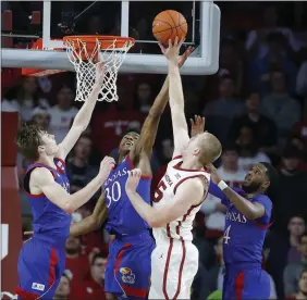  ?? [BRYAN TERRY/ THE OKLAHOMAN] ?? Oklahoma's Brady Manek puts up a shot between Kansas' Christian Braun, left, Ochai Agbaji, center, and Isaiah Moss, right, during Tuesday night's Big 12 basketball game at Lloyd Noble Center.