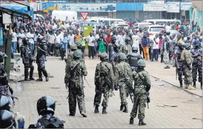  ?? Ronald Kabuubi ?? The Associated Press Ugandan army soldiers stand in front of a crowd during protests by supporters of Ugandan pop star-turned-lawmaker Bobi Wine, whose real name is Kyagulanyi Ssentamu, Friday in Kampala, Uganda.