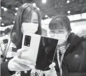  ?? CHINATOPIX ?? China is focusing its drive to become technologi­cally independen­t. Above, women in face masks last month at the Mobile World Congress in Shanghai, China.