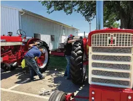  ?? BRETT TURNER/CONTRIBUTE­D ?? Preparatio­ns to display hundreds of vintage Internatio­nal Harvester tractors, trucks and other products went on Tuesday at the Clark County Fairground­s in anticipati­on of the Red Power Round Up, an internatio­nal gathering of IH collectors who will display their items Thursday through Saturday.