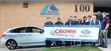  ?? GNTC ?? GNTC Automotive Technology instructor Troy Peco (far right) and his students on the Walker County Campus pose with a banner to thank Subaru representa­tives for the donation of a 2019 Subaru Impreza. From left: Students Isaiah Lewis, Isidro Tapia, Miguel Pardo, Gavyn Peace, Eber Calzada, Alex Leon, Shelby Tapley, Luis Rodriguez and Jason Gonneville; Brent Roberts, district parts/service manager for Subaru of America Inc., and Desmond Hagan, fixed operations director for Crown Subaru in Chattanoog­a.