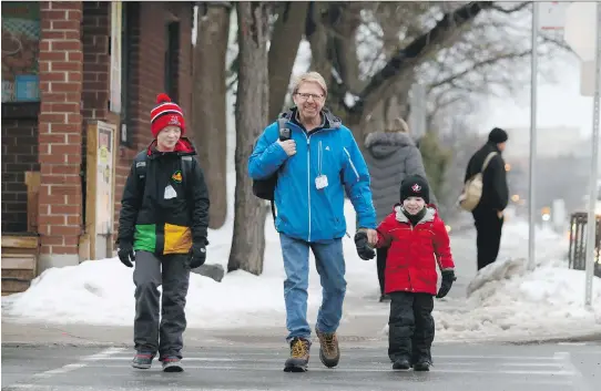  ?? ERROL McGIHON ?? Dave Loehr walks to Hopewell Avenue Public School with his sons Spencer, left, and Adam. He foresaw a “massive movement” of students caused by relocating English programs.