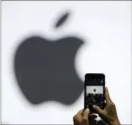  ?? MARCIO JOSE SANCHEZ — THE ASSOCIATED PRESS FILE ?? In this Monday file photo, a person takes a photo of an Apple logo before an announceme­nt of new products at the Apple Worldwide Developers Conference in San Jose. Apple is getting ready to use iPhone cameras as an entryway into the strange world of...