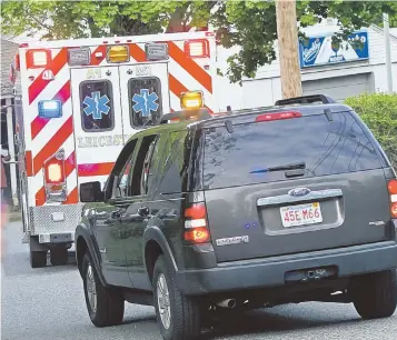  ?? STAFF PHOTO BY STUART CAHILL ?? END OF STANDOFF: An ambulance leaves the scene on Watch Street in Oxford yesterday, where state police killed suspect Jorge Zambrano. He was sought in the fatal shooting of Auburn police officer Ronald Tarentino Jr.