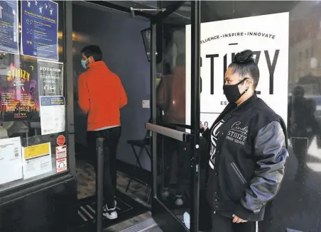  ?? Yalonda M. James / The Chronicle ?? Cindy De La Vega, the first Latina dispensary owner in S.F., opens the door for a customer at her store, STIIIZY Union Square.